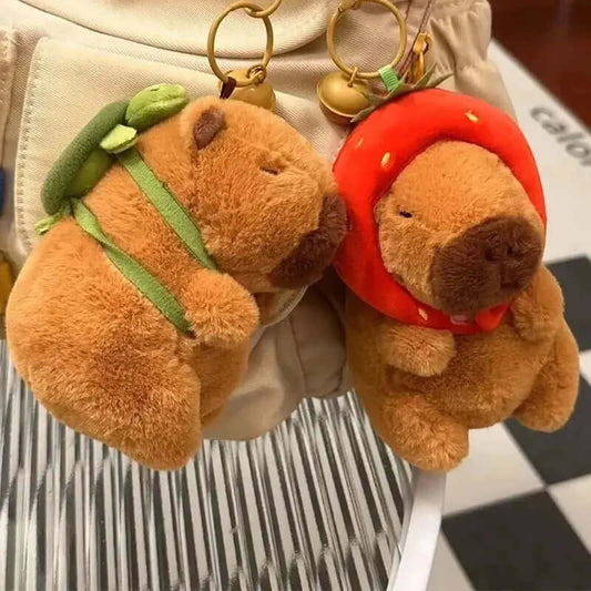 Cute capybara plush keychains in strawberry and backpack designs, perfect for adding charm to your accessories.