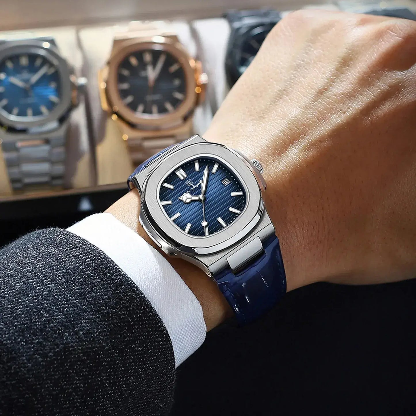 Stylish luxury men's watch with blue dial and leather strap, showcased on a wrist among elegant timepieces.