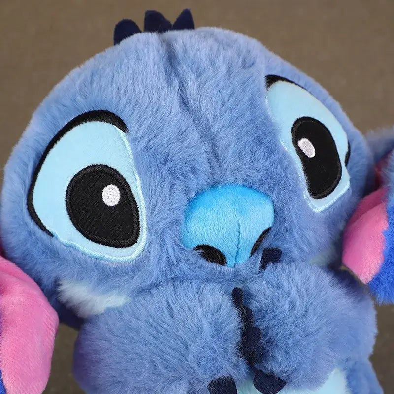 Blue Stitch plush doll with pink ears, featuring large eyes and soft fur, perfect for kids’ gifts and soothing sleep toys.