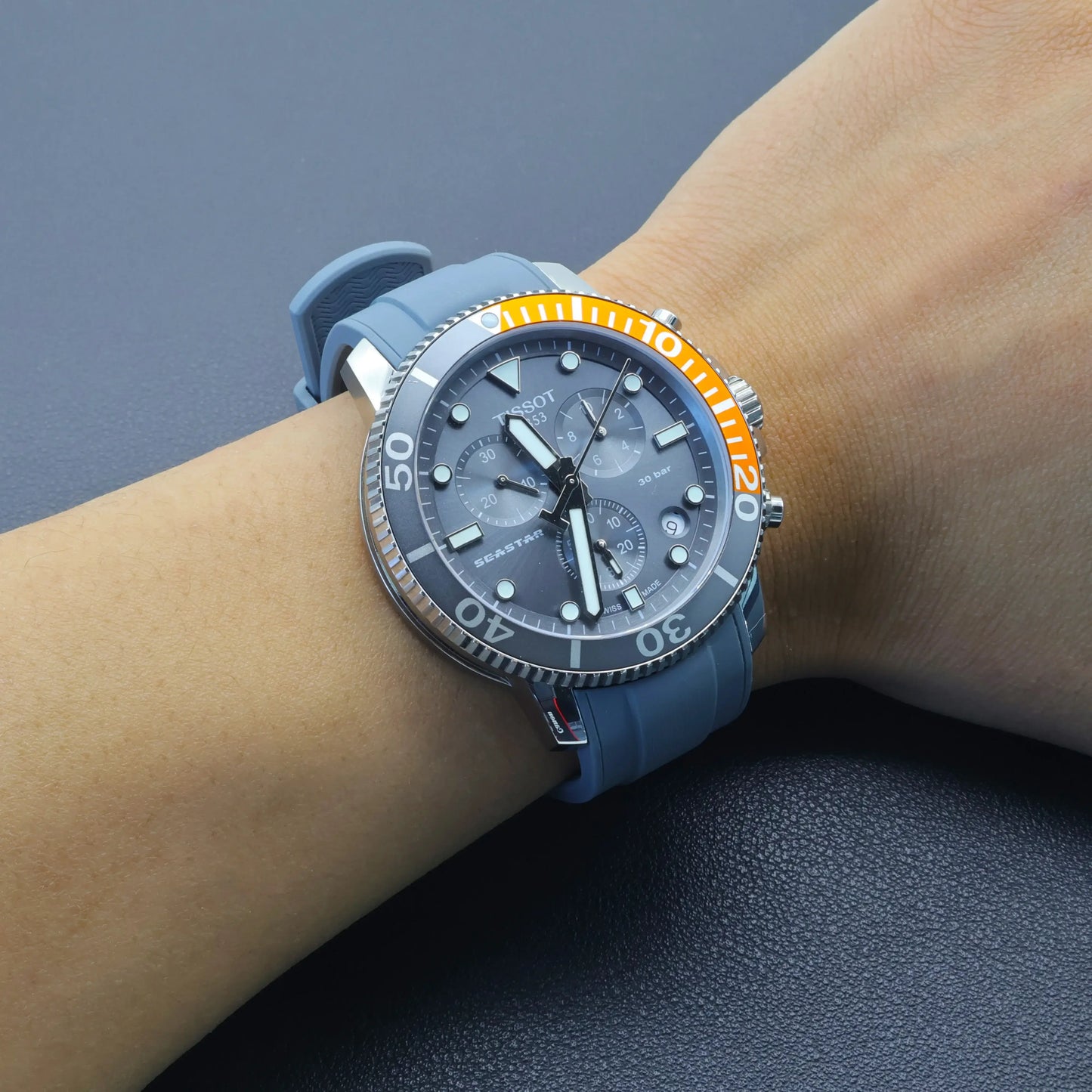 T-Star T120.417 watch with a high-end liquid silicone strap and orange accent, worn on wrist.
