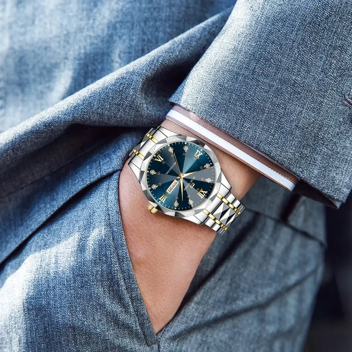 Luxury men's watch with blue dial and gold accents, worn on a stylish wrist in a gray outfit.