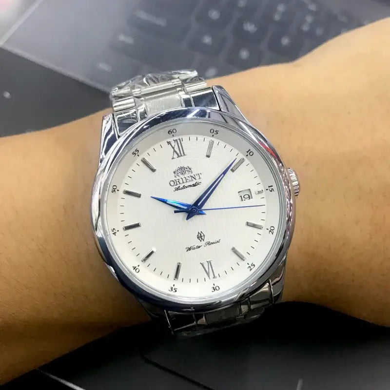 Orient AAA luxury men's watch featuring a mechanical tourbillon, all-steel design, and blue accents on a white dial.