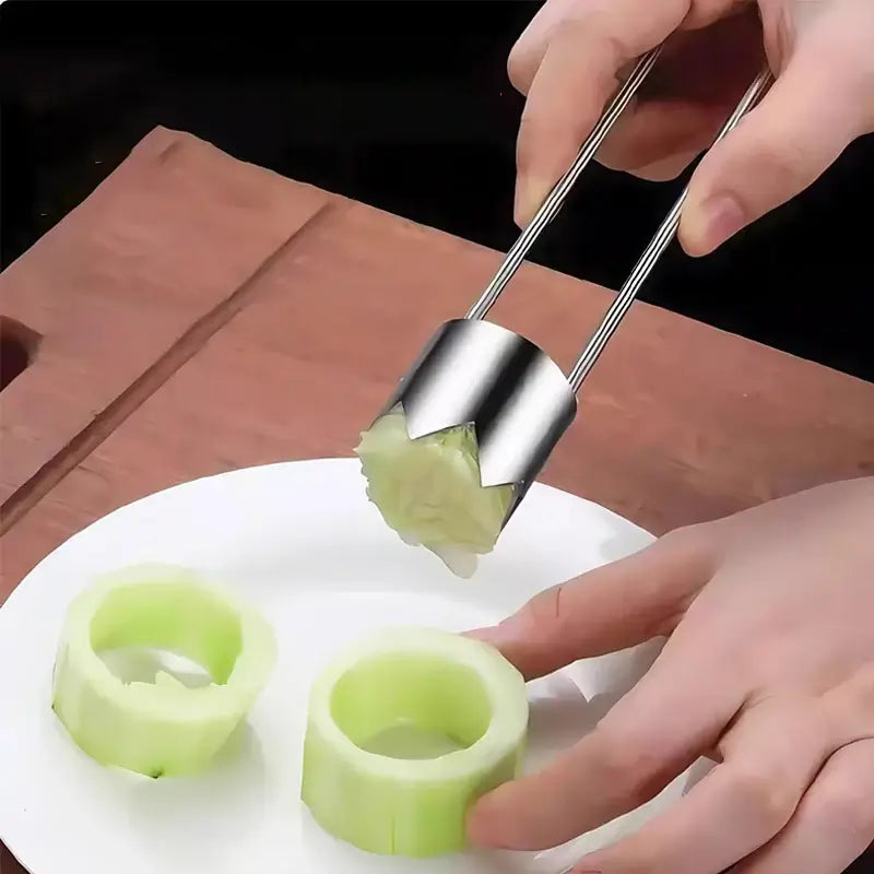 User extracting cores from cucumber slices using a stainless steel fruit corer tool on a white plate.