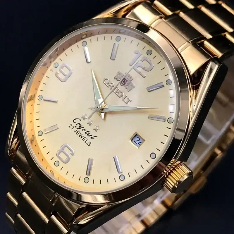 Orient luxury gold automatic watch with cream dial, date display, and metallic strap, showcasing high-quality craftsmanship.