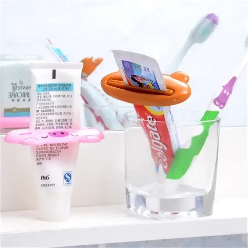 Colorful cartoon toothpaste squeezer and toothbrush holder with toiletries in a bathroom setting.