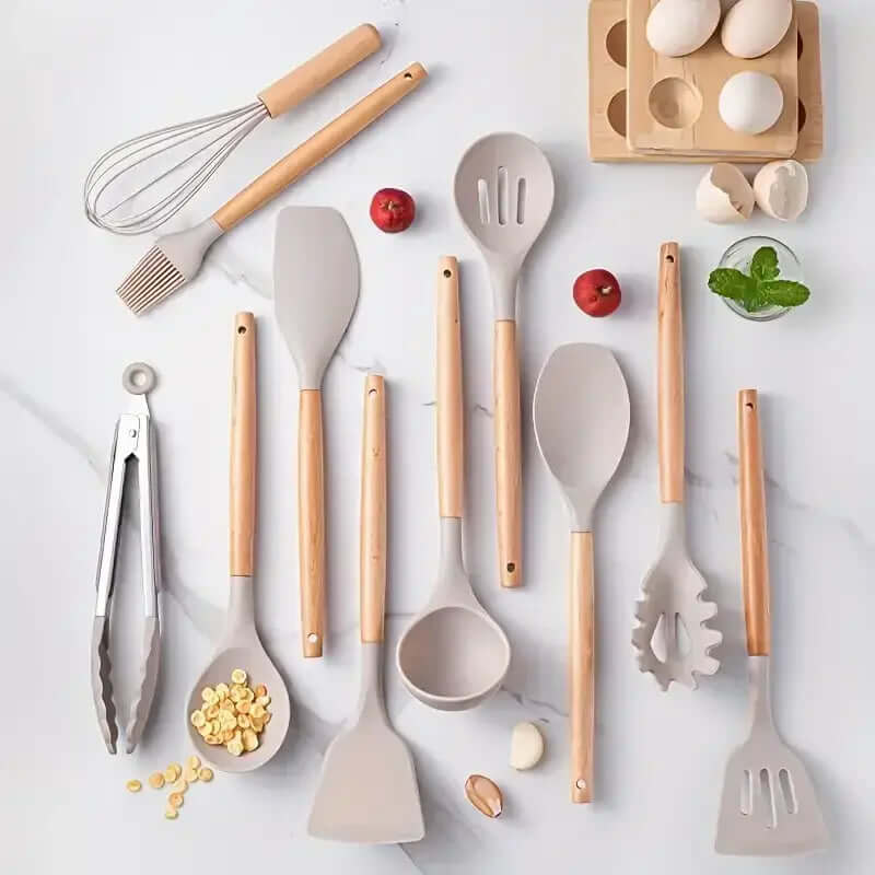 Colorful 12-piece kitchenware set with non-stick silicone utensils and wooden handles on a marble countertop.