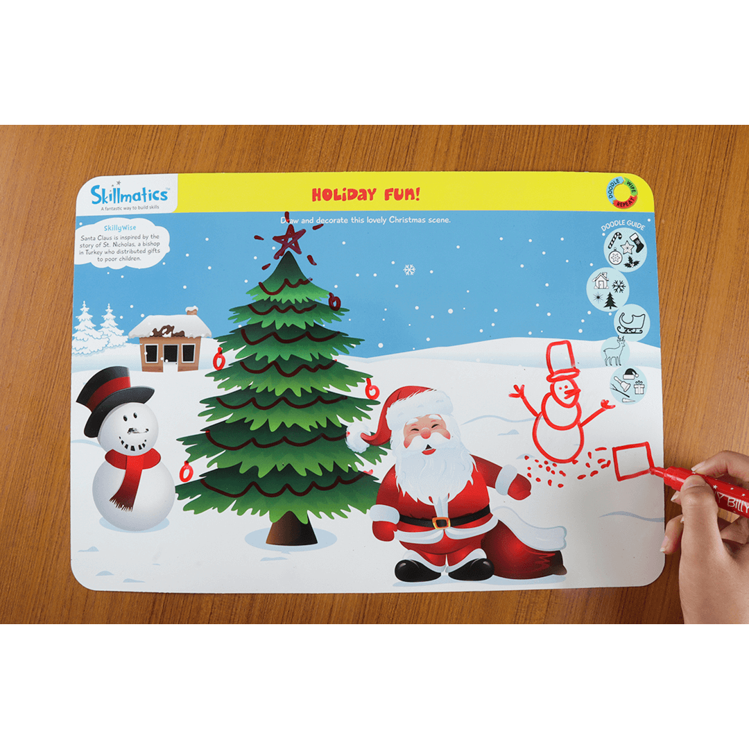 Child drawing on Skillmatics reusable activity mat with holiday theme, featuring Santa and snowman, using red dry erase marker.