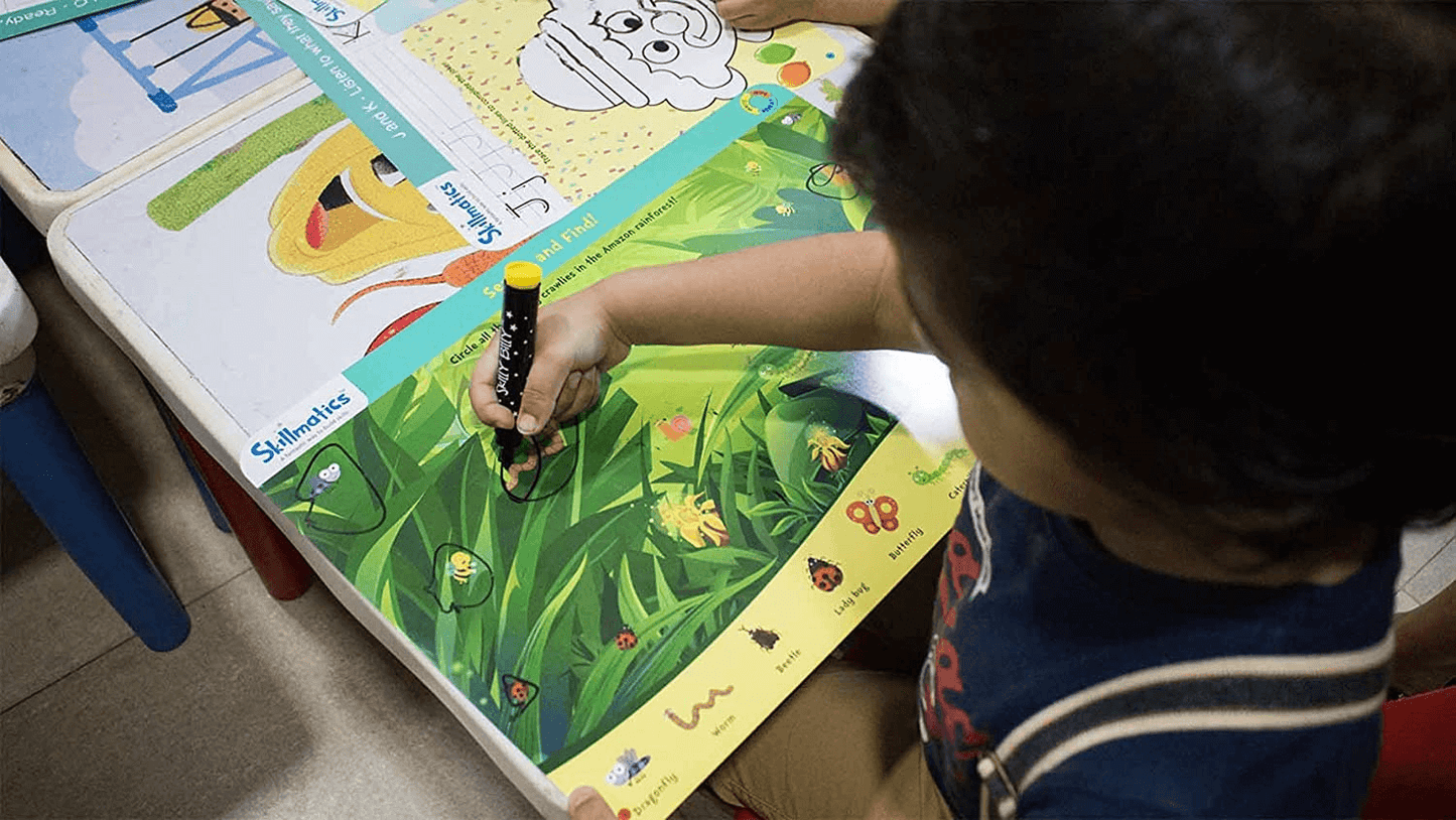 Child engaging with animal activity mat from Skilly Billy, using pen to learn about 75+ animals, enhancing creative thinking and focus.