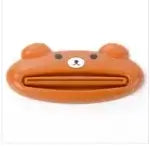 Cartoon bear-shaped toothpaste squeezer, multi-function kitchen and bathroom tool in orange plastic.