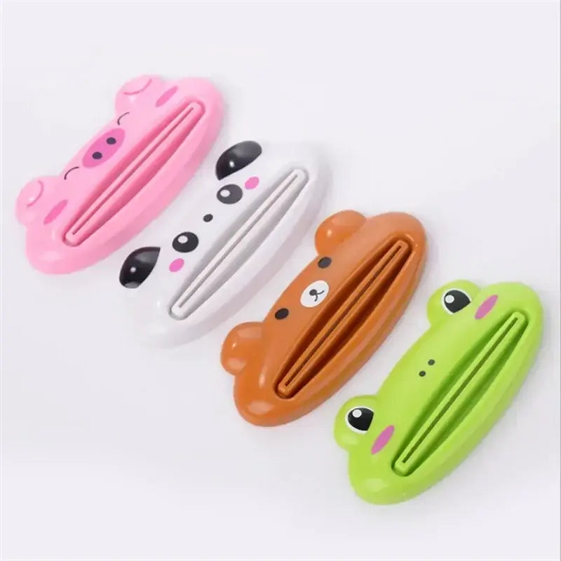 Colorful cartoon toothpaste squeezers in the shape of a pig, panda, bear, and frog for bathroom decoration and utility.