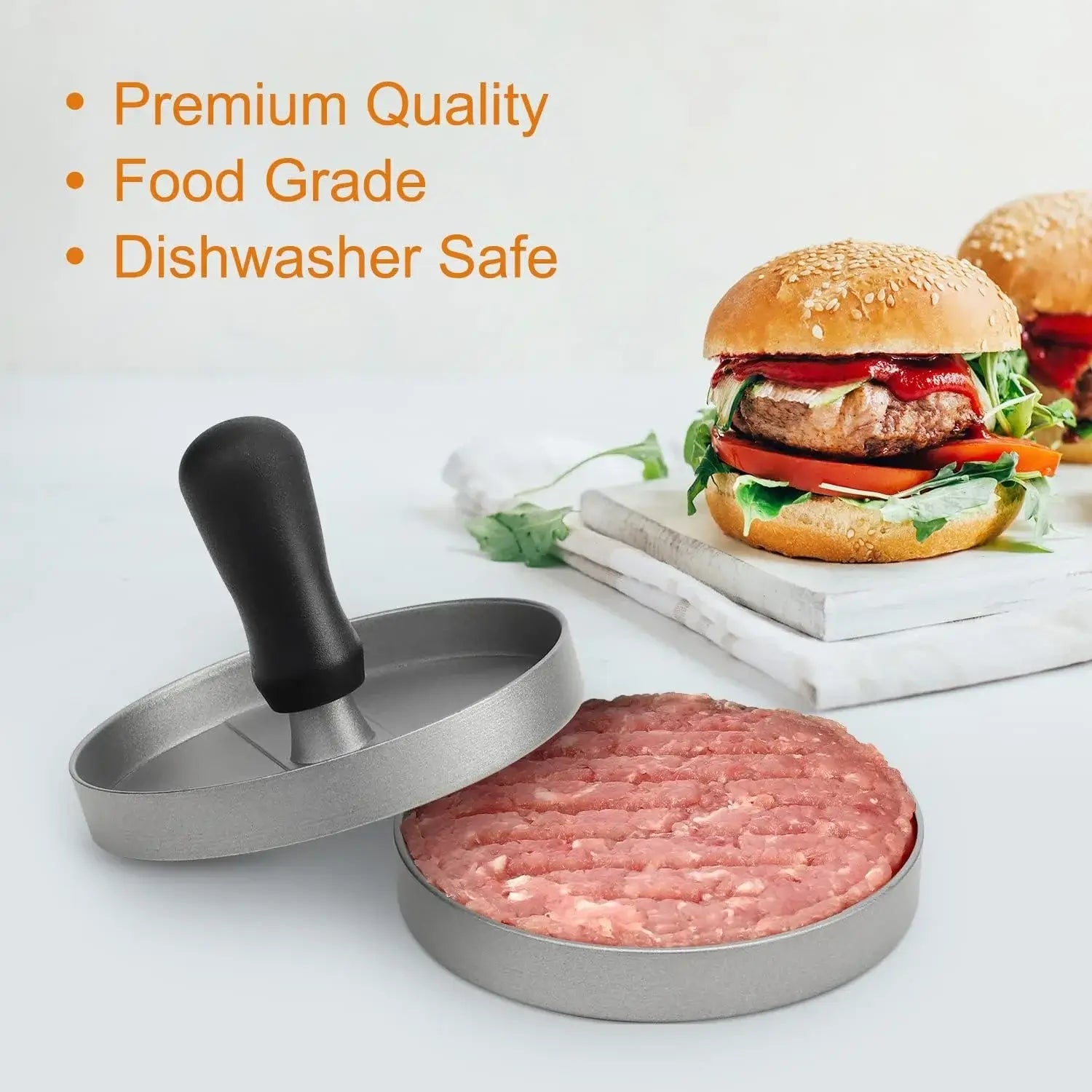 Non-stick burger press with grooves, ergonomic handle, and raw patty beside a delicious hamburger on a kitchen counter.