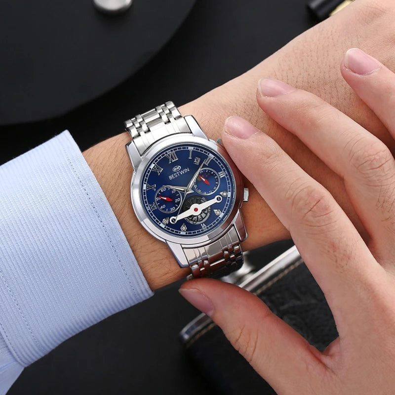 Luxury men's watch with moon phase worn on wrist, featuring a stainless steel band and blue multi-dial face.